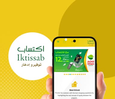 Iktissab - هاتف محمول ممسوك في يد بخلفية صفراء.